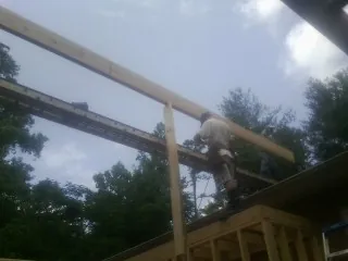 Carpenter setting a ridge beam over a new addition frame — Ice Dam Removal by Roofing Brothers in Mountain Home Afb