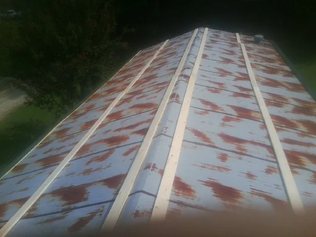 Rusted metal roof panels with new wood purlins before replacement — Storm Damage Roof Repair in Mountain Home Afb by Roofing Brothers