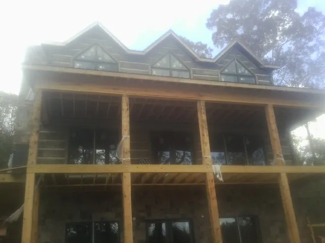 Dormers and porch framing on a large log home under construction — Roof Coating work by our crew in Mountain Home Afb