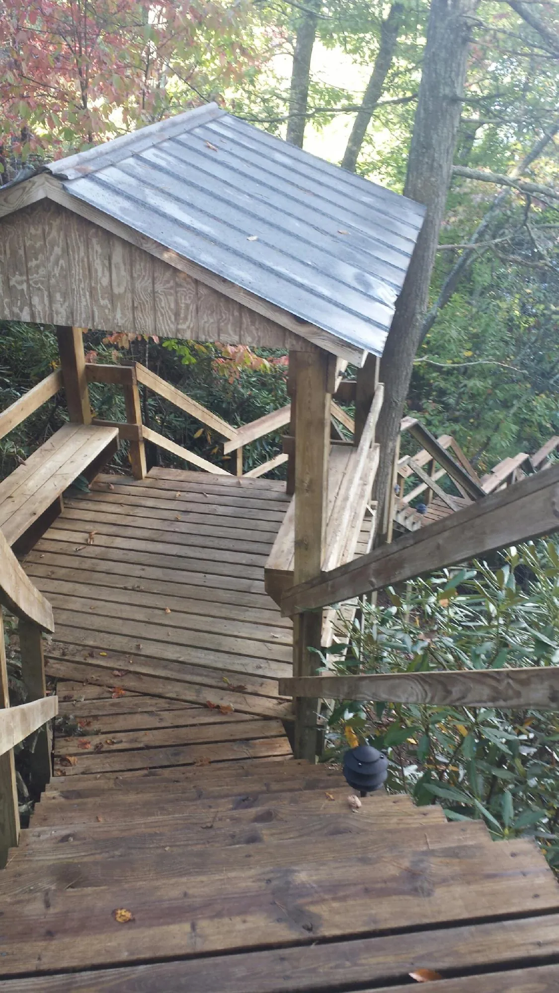 Metal roofed shelter over wooden steps on a wooded walkway — Skylight Repair & Installation work by our crew in Mountain Home Afb