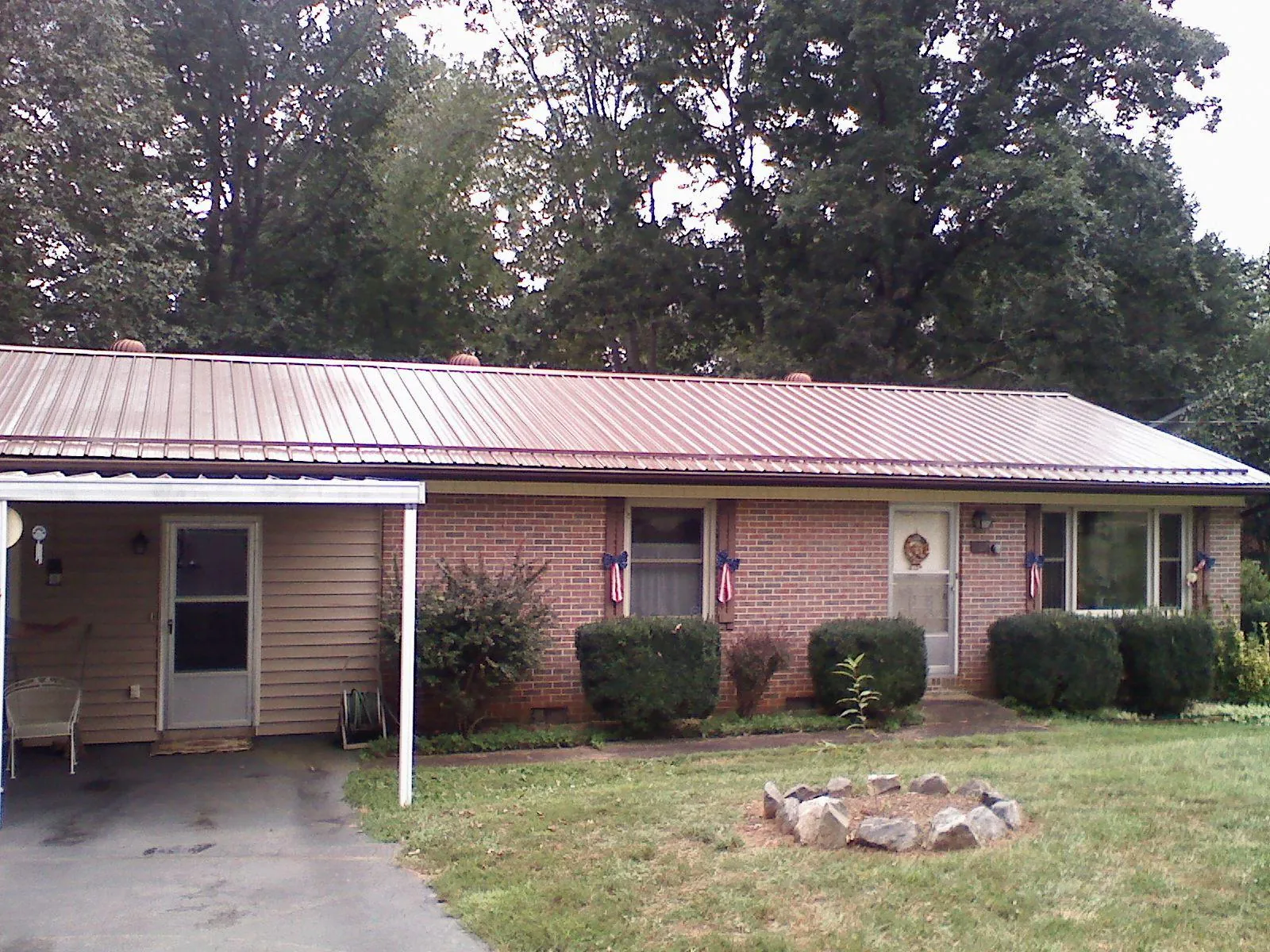 Bronze metal roof and carport on a brick ranch home — Roof Repair work by our crew in Mountain Home Afb